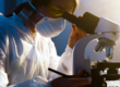 A researcher looking through a microscope