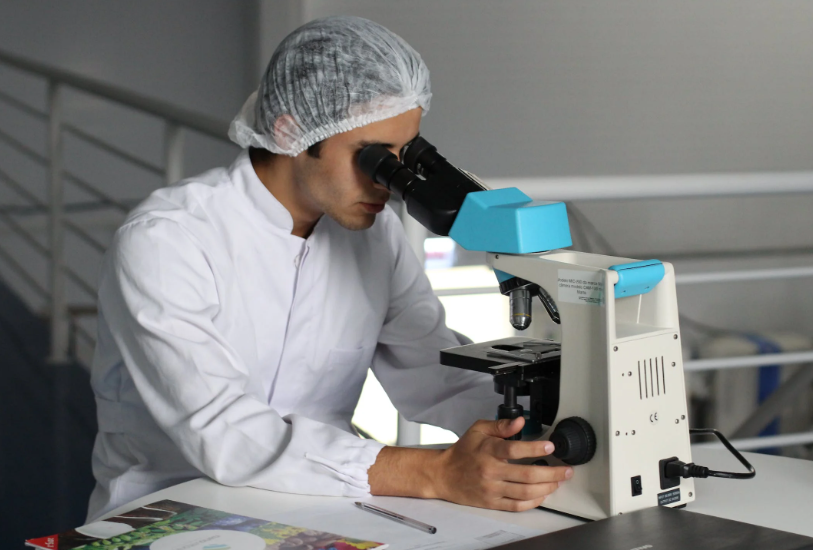 Clinician using a microscope and data management in clinical trials.