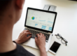 A man uses a laptop while using tools for data management in a clinical trial.