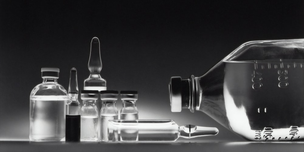 Variety of drugs in vials and an IV bottle.